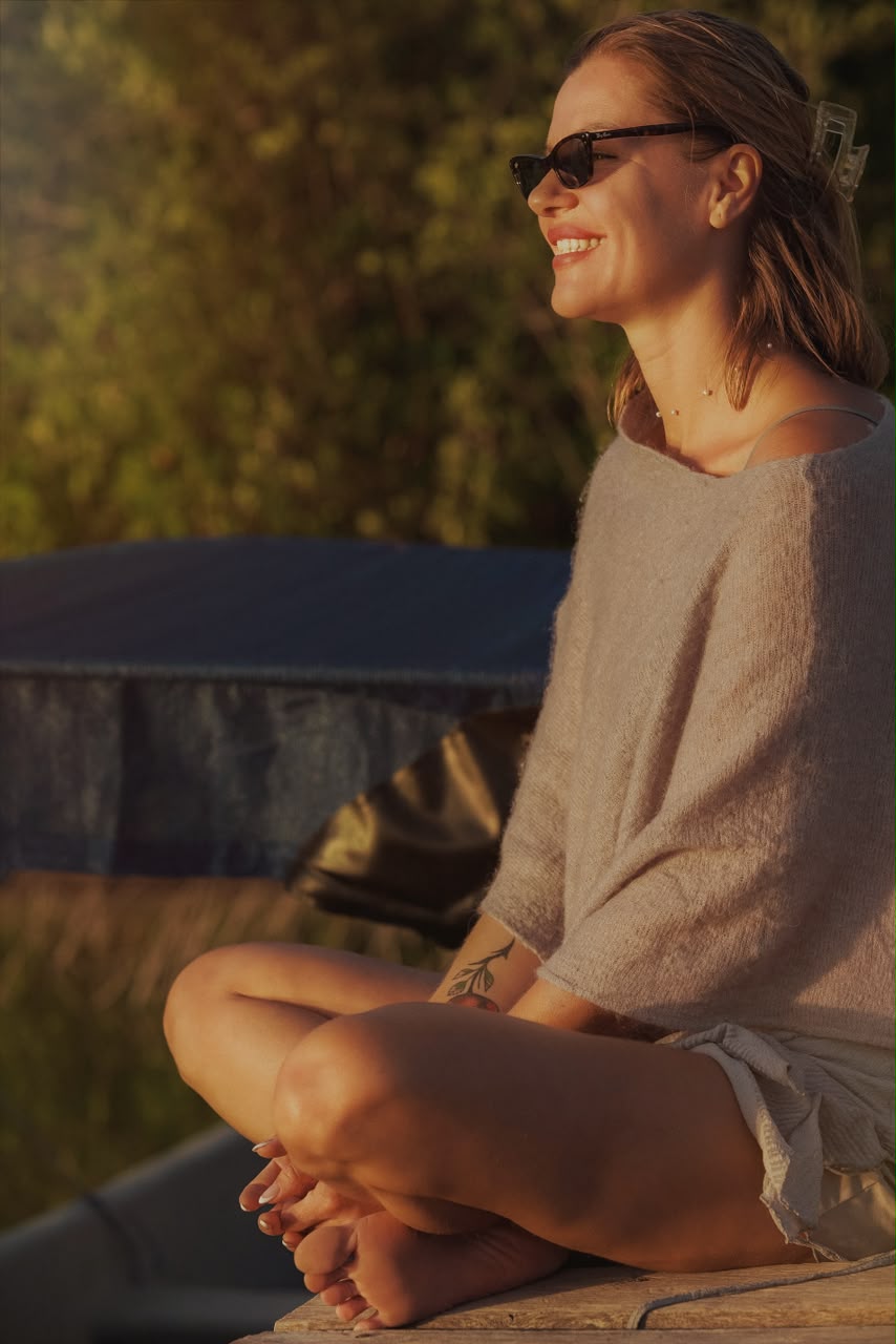 Katya Noades sitting cross-legged in warm evening sunlight